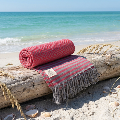 Hambamtuch MAHINA von BeachAndSteam, Baumwoll-Strand- und Saunatuch mit bunten Streifen, lässig über eine Liege drapiert