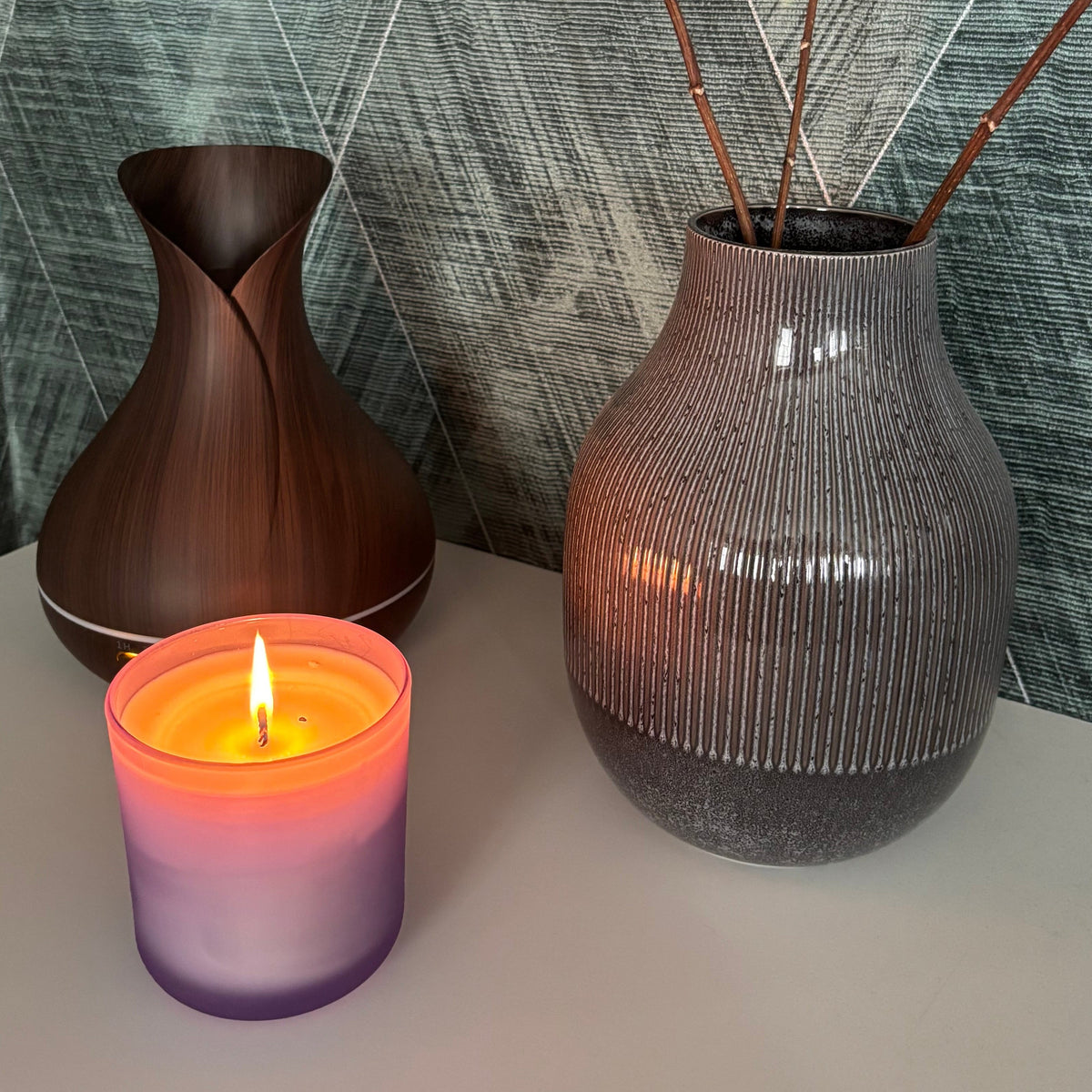 Aroma Diffusor in Holzoptik mit brennender Kerze und Vase