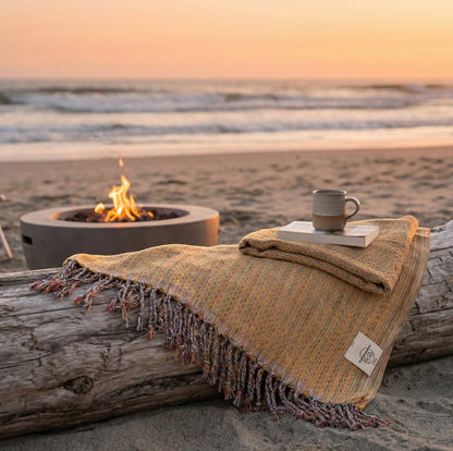 Gelbes Hamamtuch Ocean auf einem Treibholz am Strand bei Sonnenuntergang