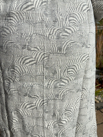 Nahaufnahme des Trimita Kapuzenbademantels Zebra: grau-weißes Zebramuster auf Musselin-Baumwolle