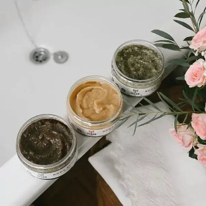 Drei VEGAN FOX Körperpeelings Ingwer, Kaffee und Pfefferminze am Badewannenrand